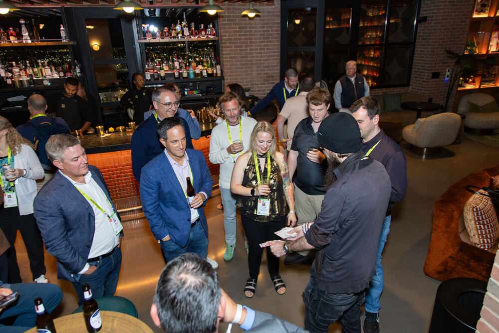 Guests gather around a magician at an evening reception