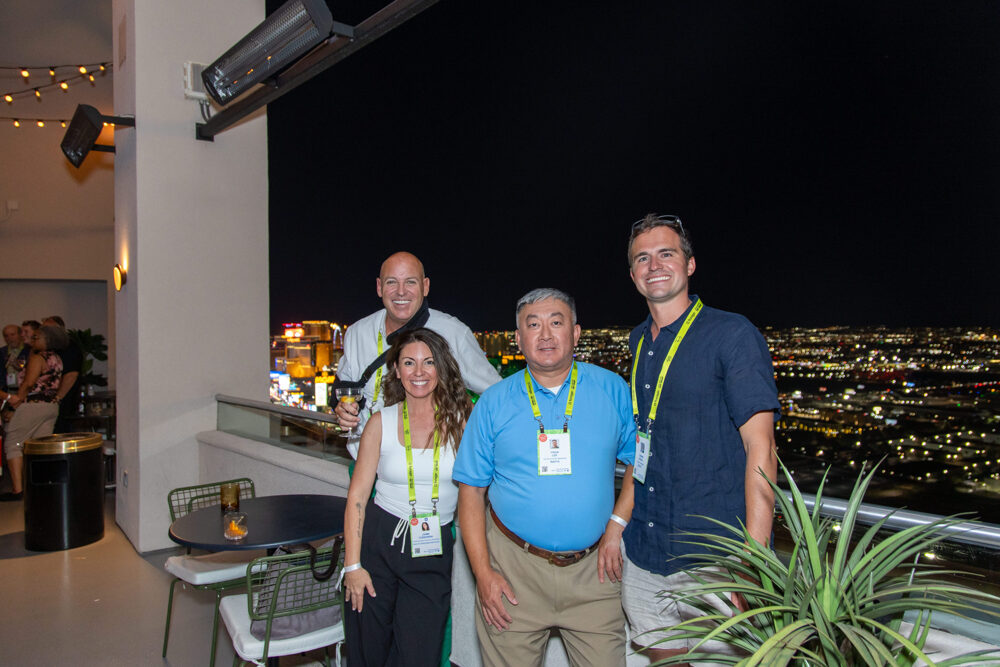 Colleagues pose on a rooftop terrace during an evening reception